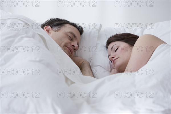 Couple sleeping in bed.