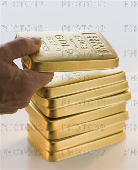 Man picking up gold bar.