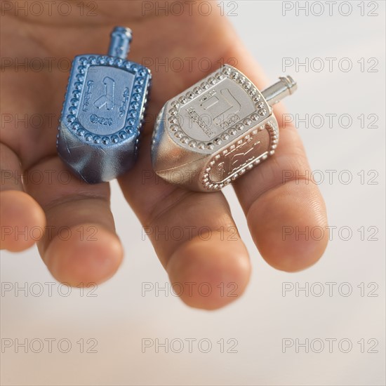 Close up of dreidel in man’s hand.