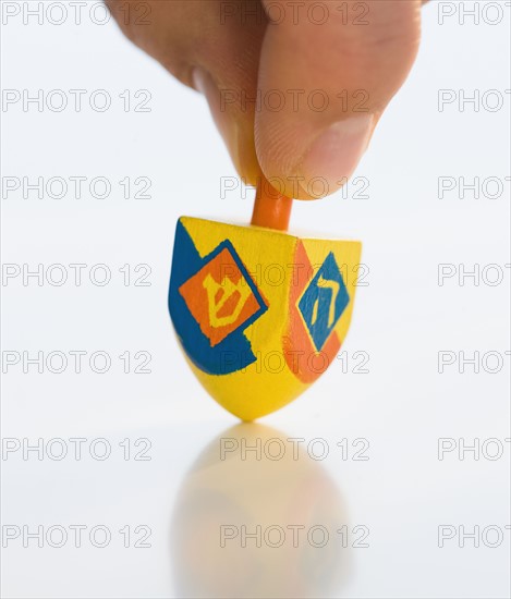 Close up of man spinning dreidel.