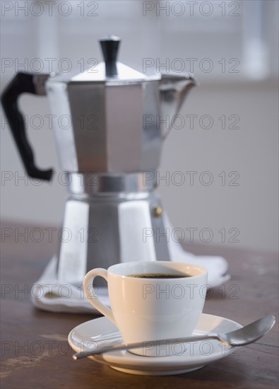 Espresso in front of coffee pot.