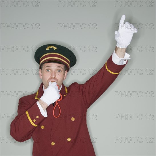 Doorman blowing whistle and raising arm.