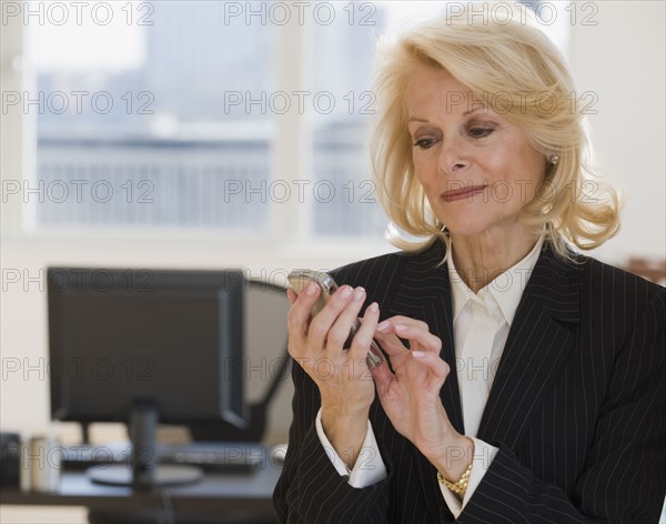 Businesswoman dialing cell phone.