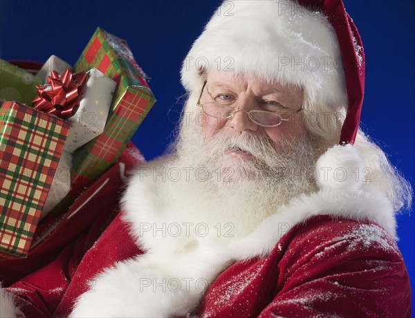 Santa Claus next to bag of toys.