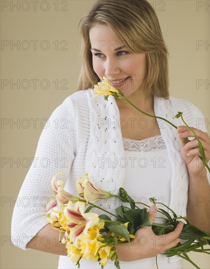 Woman smelling cut flower.