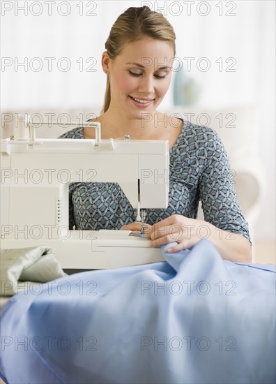 Woman using sewing machine.