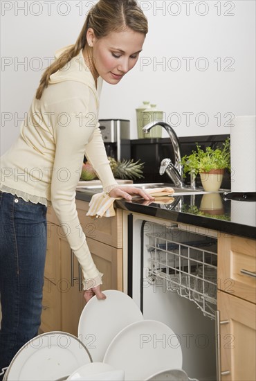 Woman loading dishwasher.