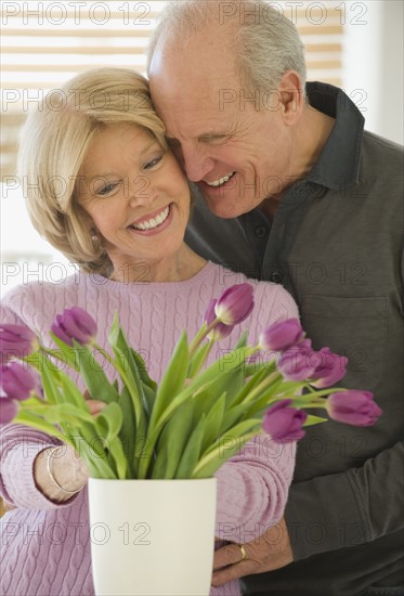 Senior couple looking at flowers.