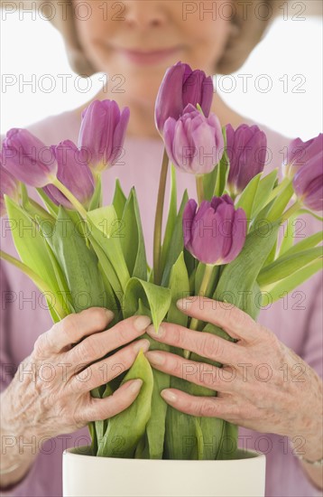 Senior woman arranging flowers.