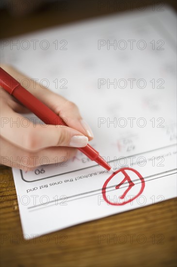 Teacher writing F grade on worksheet.