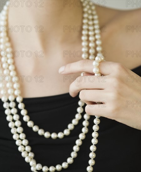 Woman wearing strands of pearls.