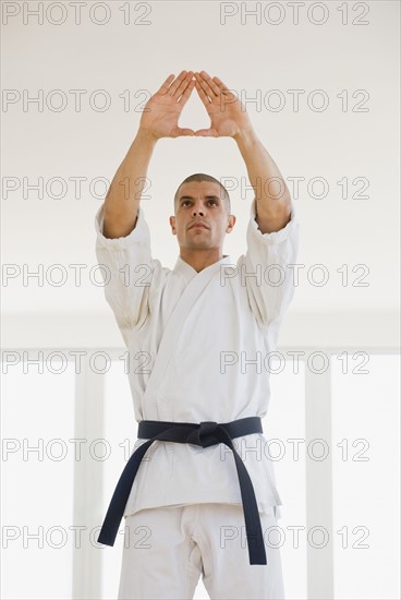 Hispanic male karate black belt in stance.