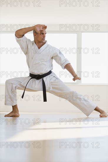 Hispanic male karate black belt in fighting stance.