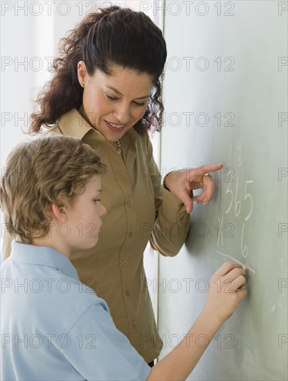 Hispanic teacher helping student with math problem.