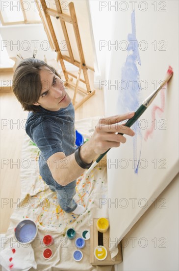 Man painting on easel.