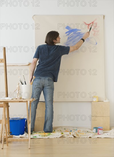 Man painting on easel.