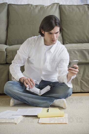 Man looking at electronic organizer.