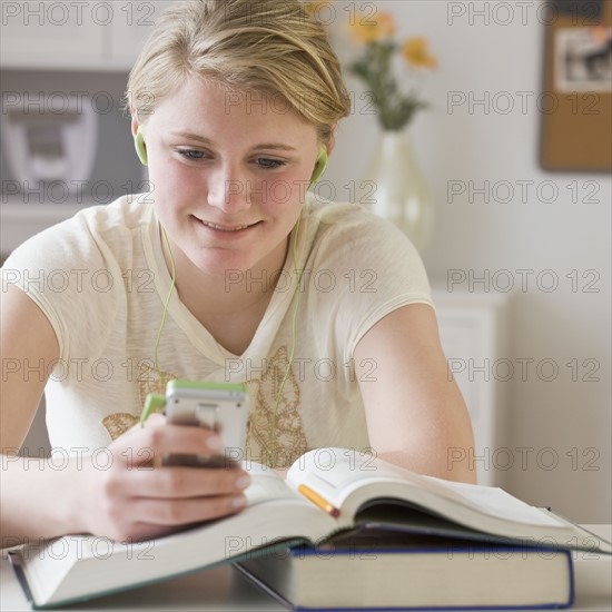 Teenaged girl looking at mp3 player.