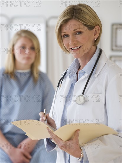 Female doctor holding chart.