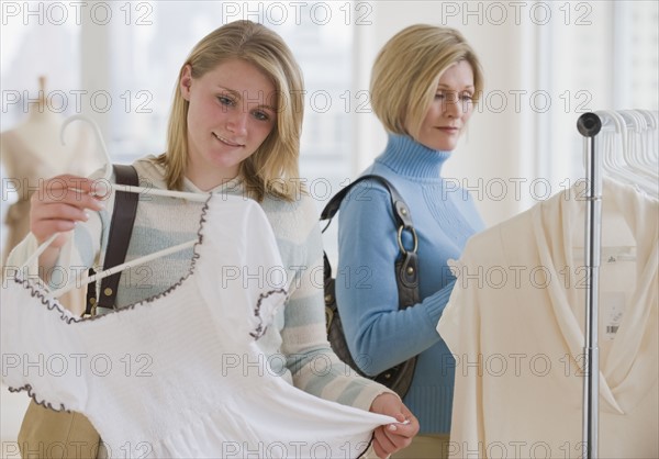 Mother and daughter clothes shopping.