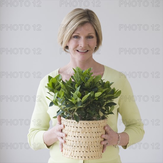Woman holding potted plant.