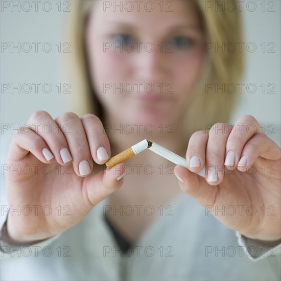 Woman breaking cigarette.