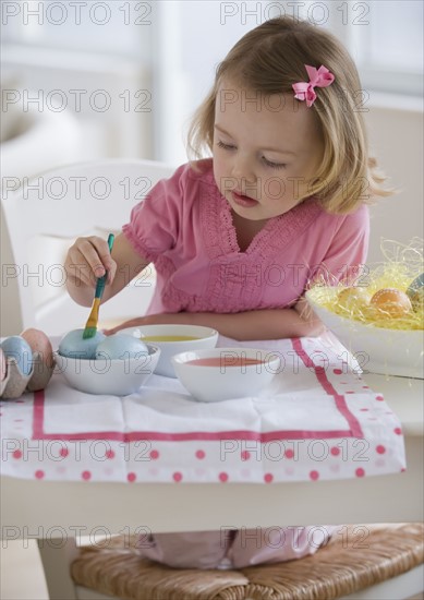 Young girl decorating eggs.