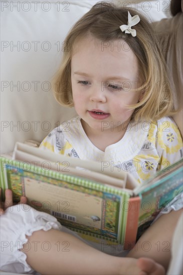 Young girl looking at book.