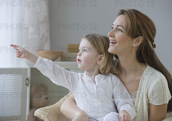 Mother and daughter pointing and looking.