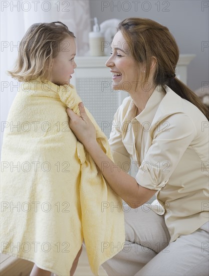 Mother drying daughter with towel.