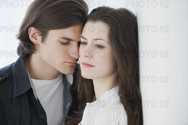 Man leaning forehead on girlfriend’s temple.