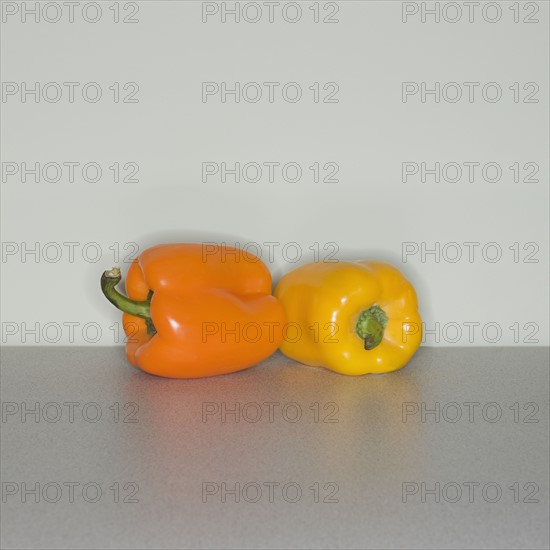 Orange and yellow bell peppers on table.