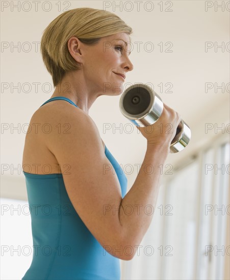 Woman exercising with dumbbell.