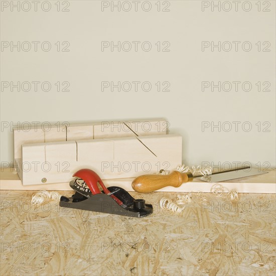 Woodworking plane and awl next to wood blocks.