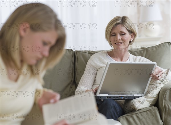 Mother and daughter relaxing in livingroom.