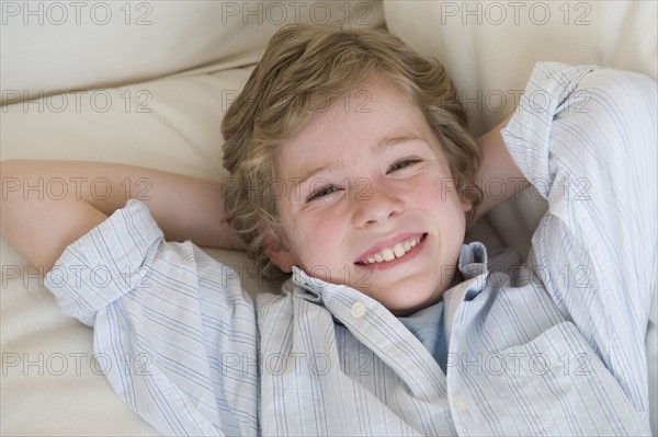 Boy laying on sofa.