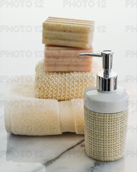 Stack of soap and towels next to lotion.