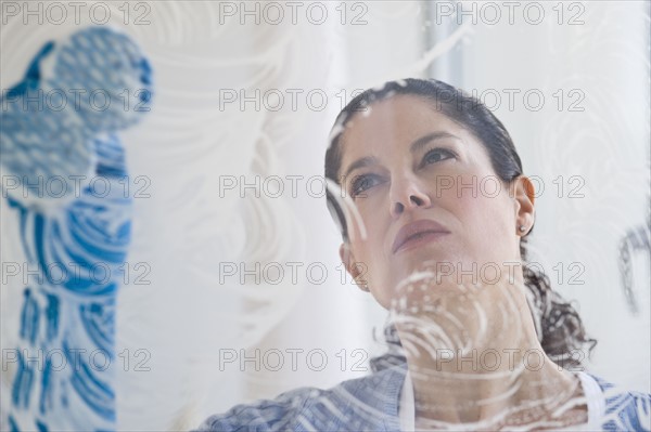 Hispanic woman washing window.