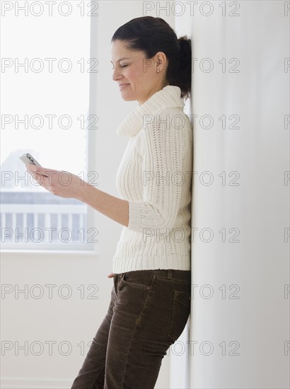 Hispanic woman looking at electronic organizer.