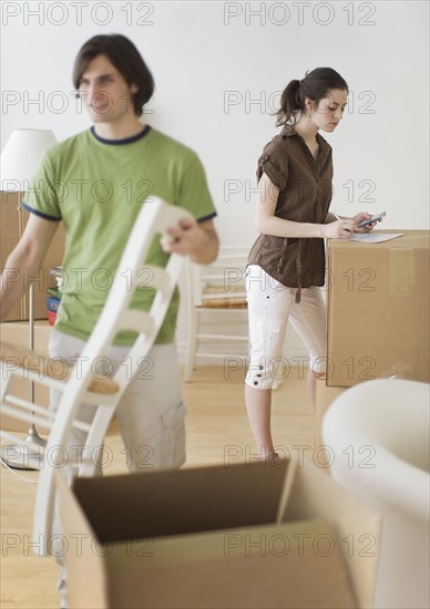 Couple and moving boxes in new home.