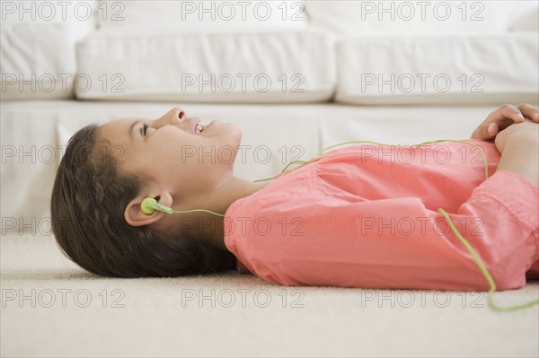 Hispanic girl listening to headphones.