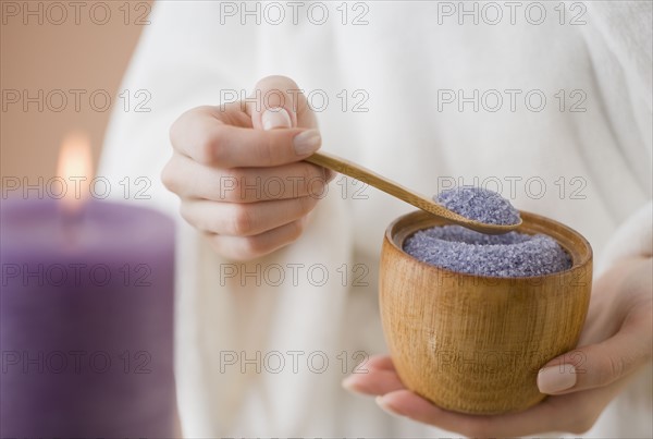 Woman spooning bath salts.