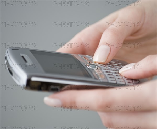 Woman dialing cell phone.