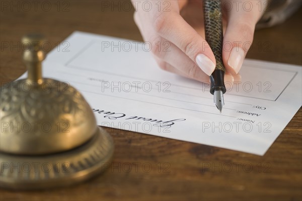 Woman filling out hotel registration.