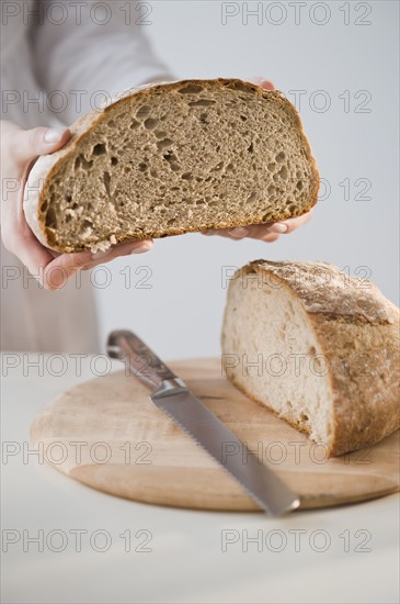 Woman holding loaf of bread.