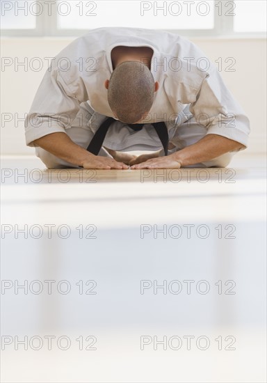 Hispanic male karate black belt bowing.