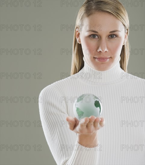 Woman holding glass globe.