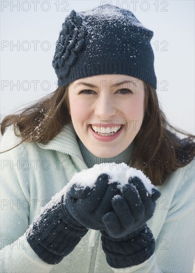 Woman holding handful of snow.