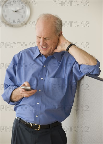 Senior businessman looking at cell phone.