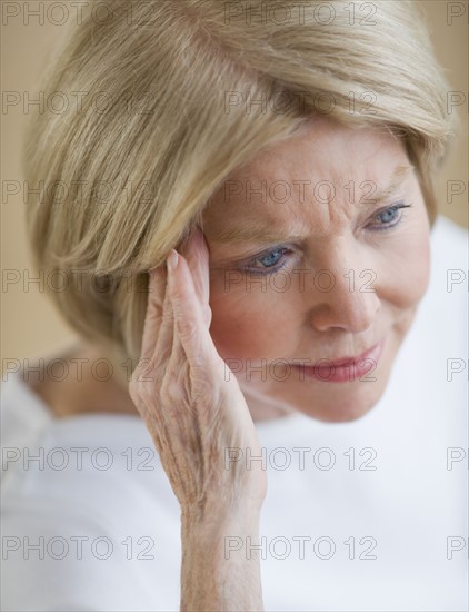 Senior woman rubbing temple.